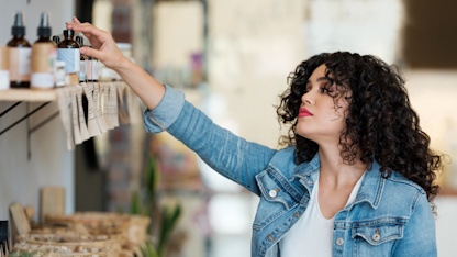 bir mağazada kozmetik ürünleri arayan bir kadın