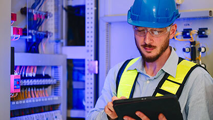 Electrical engineer working in control room at industry factory